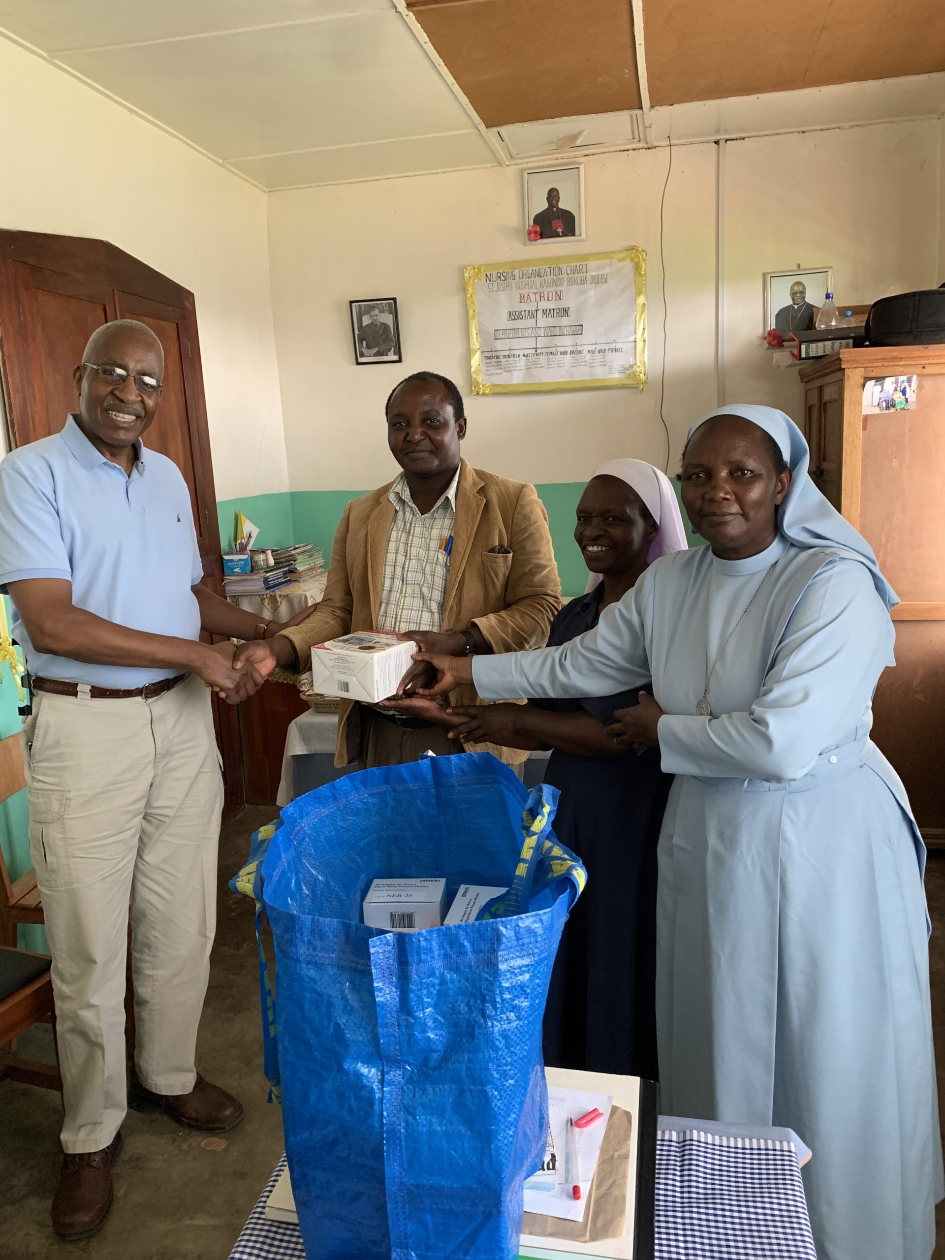 Health care professionals shake hands and exchange gifts of medical supplies