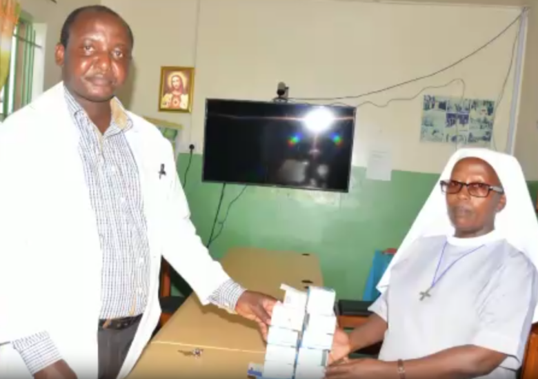 two healthcare professionals pose with medical supplies