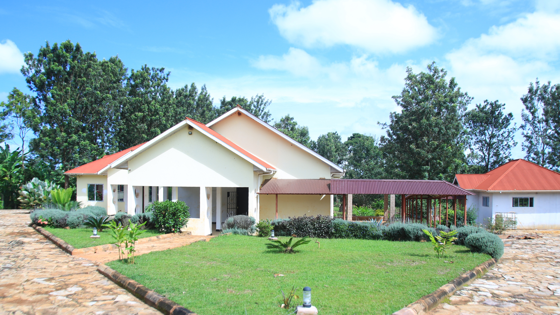 a health clinic - white building with a red roof and manicured green lawn and stone walkway