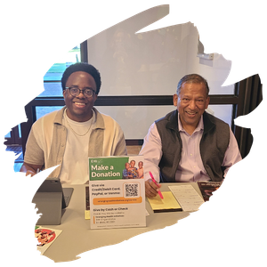 two men sitting at a table together collecting donations